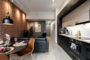 a kitchen and living room with a black leather couch at City Home Alvari, jäähdytys, ilmainen pysäköinti autohallissa in Kuopio