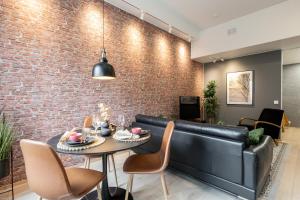 a living room with a black leather couch and a table at City Home Alvari, jäähdytys, ilmainen pysäköinti autohallissa in Kuopio +16 photos