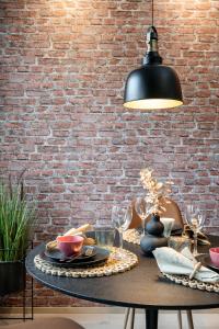 a table with a black lamp and a brick wall at City Home Alvari, ilmainen pysäköinti, free parking in Kuopio