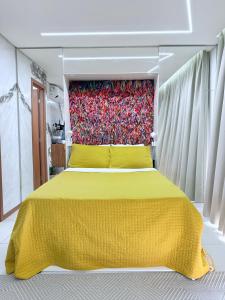 ein Schlafzimmer mit einem gelben Bett und einer roten Wand in der Unterkunft Studio luxo na Barra in Salvador
