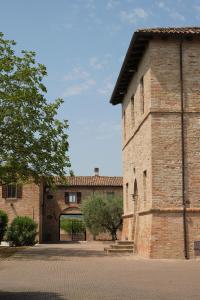 un grande edificio in mattoni con un arco di fronte di Castello di Ribano Luxury Suites a Montalbano