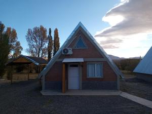 a small red brick house with a white door at Complejo de Cabañas y Comidas Ruta 43 in Chos Malal +10 photos