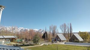 a group of houses with mountains in the background at Complejo de Cabañas y Comidas Ruta 43 in Chos Malal