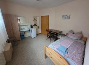 a bedroom with a bed and a kitchen with a table at Gasthaus für Monteure in Niederzissen