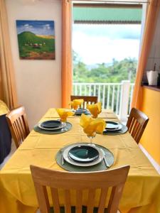 a dining room table with a yellow table cloth at Maison charmante avec jardin clos à Sainte-Anne in Sainte-Anne