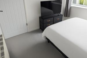 una camera con letto, TV e cassettiera di Central Cornwall Home a Redruth