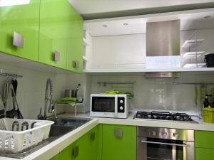 a kitchen with green cabinets and a microwave at Forte Stagio Stagi in Forte dei Marmi