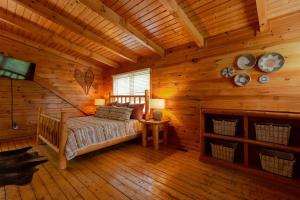 sypialnia z łóżkiem w chacie z bali w obiekcie Gorgeous Views! New Hot Tub~Game Room~3 King Beds w mieście Park Settlement +46 zdjęć