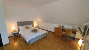 a bedroom with a bed and a desk with two lamps at Baroc Boutique Hotel in Topliţa
