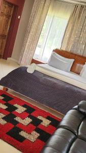 a bedroom with a bed with a rug and a window at Mutanda Georgie's Bar & Grill in Mutanda