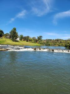 a river with a waterfall in the middle at Mutanda Georgie's Bar & Grill in Mutanda