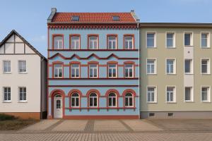 a building with a painting on it next to two buildings at Apartment für bis zu 6 Personen mit Balkon in Halberstadt
