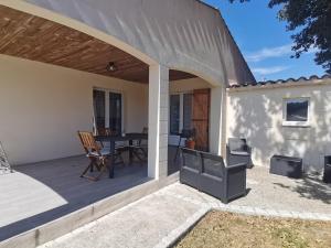 a patio with a table and a grill at Gîtes Le Chemin du Romarin in Meursac