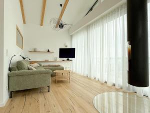 a living room with a couch and a tv at Ava Lodge am Hainer See in Neukieritzsch