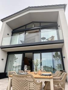 een glazen huis met een houten tafel en stoelen bij Ava Lodge am Hainer See in Neukieritzsch