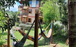 a couple of hammocks in front of a building at Pousada Riacho Das Pedras in Gonçalves