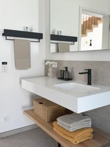 a bathroom with a white sink and a mirror at Ava Lodge am Hainer See in Neukieritzsch +12 photos