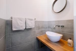 a bathroom with a white bowl sink and a mirror at Molengats vakantieappartementen in Wijlre