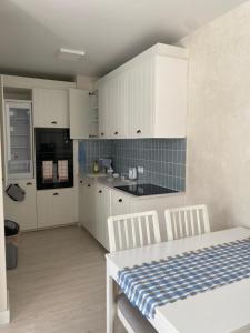 a kitchen with white cabinets and a table and chairs at Aparthaus Olive in Torrevieja
