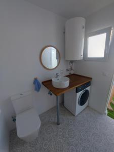 a bathroom with a toilet and a sink and a mirror at Aparthaus Olive in Torrevieja +10 photos