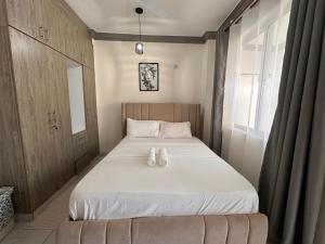 a bedroom with a bed with two white shoes on it at Nas Haven in Mombasa