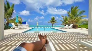a woman laying on a bench next to a swimming pool at The Sand Dollar at Cottages in Sand Bluff