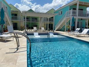 a pool at a resort with chairs and a building at The Starfish at Cottages in Sand Bluff
