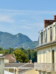 vistas a un edificio con montañas en el fondo en Le Continental - Calme et Centre-Ville, en Aix-les-Bains