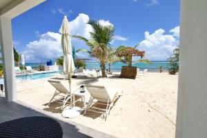 Blick auf einen Strand mit Stühlen und Sonnenschirmen in der Unterkunft The Sunrise at Cottages in Sand Bluff + 44 Fotos