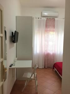 a room with a desk and a bed with a window at Villa Cenzina in Marina di Pisticci