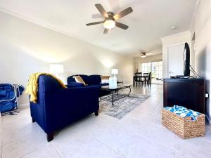 ジョージ・タウンにあるSnug Harbour View Condo #5のリビングルーム(青いソファ、天井ファン付)