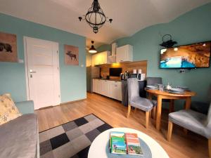 ein Wohnzimmer mit Tisch und Küche in der Unterkunft Apartamenty Nova na Krakowskiej No 3 in Bielsko-Biała + 14 Fotos