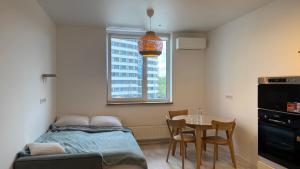 a bedroom with a bed and a table and a window at Затишне місце біля парку in Kyiv +20 photos