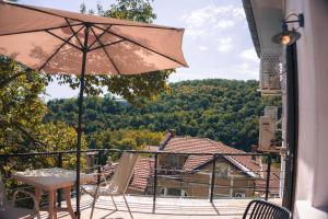 a balcony with a table and chairs and an umbrella at R34 Boutique Art Hotel in Veliko Tŭrnovo
