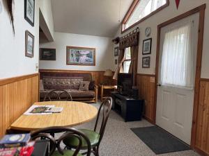 una sala de estar con una mesa y un sofá en Duxbury - Cozy Cottage on Lake Minocqua, en Minocqua