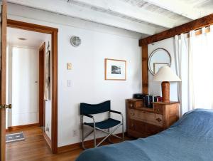 a bedroom with a bed and a chair and a dresser at The Blue Door in Oceanside