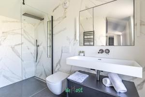 une salle de bain avec un lavabo, des toilettes et un miroir dans l'établissement Raspail B - IDF - LB - Charming house at gates of Paris 3 people, à Bois-Colombes 5 autres photos