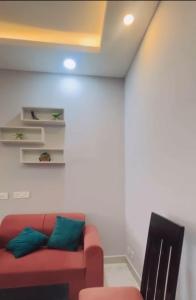 sala de estar con sofá rojo y almohadas verdes en Northeye studio, en Noida