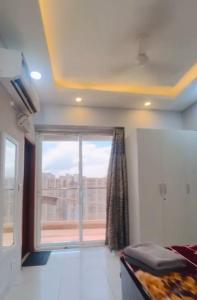 Un dormitorio con una gran ventana con vistas. en Northeye studio, en Noida