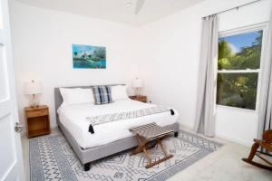 ein weißes Schlafzimmer mit einem Bett und einem Fenster in der Unterkunft The Mastic Sunnyhill Cottage in North Side