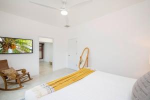 a white room with a bed and a chair at The Mastic Sunnyhill Cottage in North Side