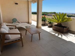 a patio with chairs and a table on a balcony at La Pau Apartaments in Mollerusa