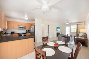 a kitchen and living room with a table and chairs at Snug Harbour View Condo #9 in George Town