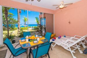 a dining room with a table and chairs and the ocean at Northern Lights #4 Condo in Old Man Bay