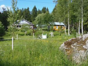a house in a field with a fence at Gula Villan in Maxmo