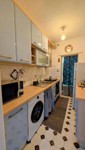a kitchen with white cabinets and a sink and a dishwasher at Sunset House in Santa Marinella