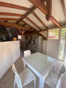 a dining room with a white table and white chairs at Villa Lolyka in Terre-de-Haut