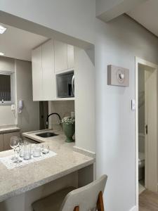 a kitchen with a counter with wine glasses on it at Refúgio Sofisticado Beira Mar in Florianópolis