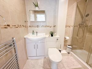 a bathroom with a toilet and a sink and a shower at Bright 3-Bedroom Aldgate Flat with Free WIFI near Tower Hill, Brick Lane & Spitalfields in London