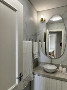 a bathroom with a sink and a mirror at Refúgio Sofisticado Beira Mar in Florianópolis